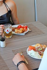 stół z dwoma talerzami jedzenia i szklanką piwa w obiekcie Delfinia Resort - All Inclusive w Kolymbii