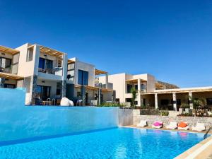 Blick auf eine Villa mit einem Pool in der Unterkunft Helios Beach Hotel & Bungalows in Karpathos