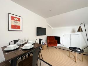 a dining room with a table and chairs and a television at The Loft, NEW, Stylish Maisonette, Central, Private Location in Lewes