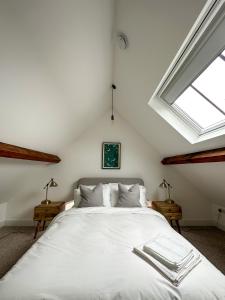 a white bed in a room with a window at The Loft, NEW, Stylish Maisonette, Central, Private Location in Lewes