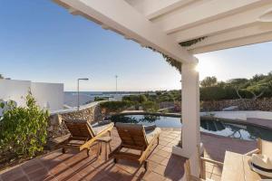 a patio with two chairs and a swimming pool at Villas Etnia in Binissafuller