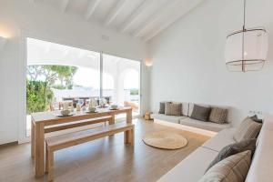 a white living room with a table and a couch at Villas Etnia in Binissafuller