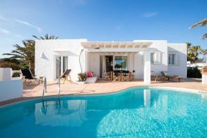 a villa with a swimming pool in front of a house at Villas Etnia in Binissafuller +5 photos