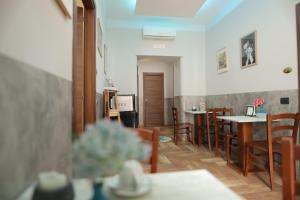 uma sala de jantar com mesas e cadeiras num quarto em L'Ammor e Napule em Nápoles