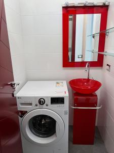 a bathroom with a washing machine and a red sink at Al Borgo in Avola
