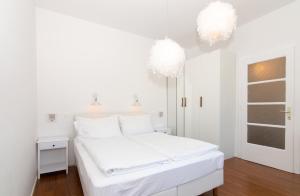 een witte slaapkamer met een wit bed en 2 verlichting bij Villa Beatrice by Locap Group in Izola