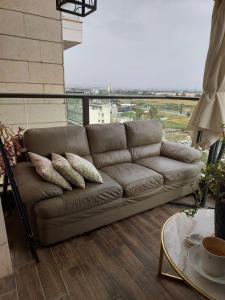 a brown couch in a living room with a view at Dudger home in Yehud