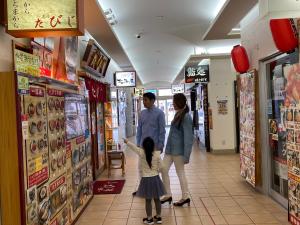 een familie die door een winkelcentrum loopt bij Tokyu Stay Hakodate Asaichi Akarinoyu in Hakodate