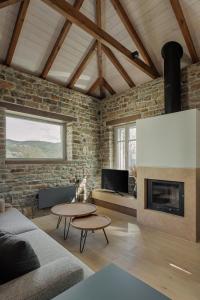 a living room with a couch and a fireplace at LozArt Traditional Stone House in Ellinikón