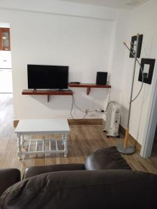 uma sala de estar com um sofá e uma televisão na parede em Alcôa House em Alcobaça