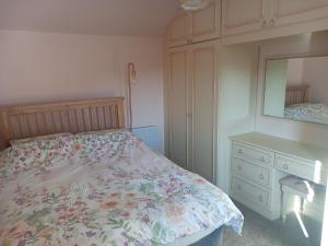BalallanにあるRoineabhal Cottageのベッドルーム1室(ベッド1台、ドレッサー、鏡付)