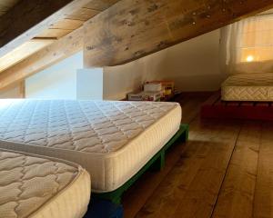 En eller flere senge i et værelse på Attic family apartment in center of Moggio