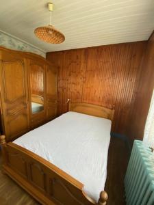 ein kleines Bett in einem Zimmer mit Holzvertäfelung in der Unterkunft ST MICHEL in Saint-Michel-en-lʼHerm