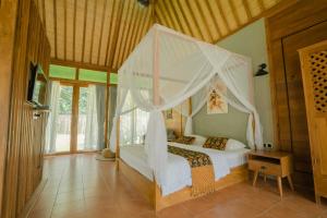 1 dormitorio con 1 cama blanca con dosel en Chandaka Borobudur, en Magelang