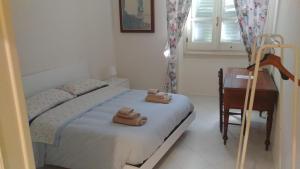 una camera da letto con un letto e due asciugamani di Casa jacaranda a Cagliari