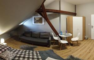 ein Wohnzimmer mit einem Sofa und einem Tisch in der Unterkunft Czarna Owca- Pokoje Gościnne in Gniezno