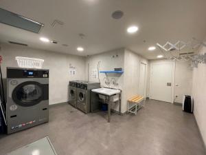 a laundry room with a washer and a washing machine at Albergue Guiana in Ponferrada