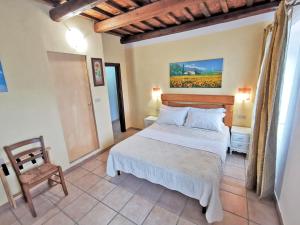 a bedroom with a large bed and a chair at Il Girasole Country Village in Massignano