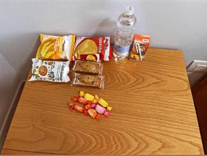 a wooden table with snacks and a bottle of water at Sweet Stay in Fiumicino