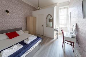 a bedroom with a bed and a table and a desk at Highlands Hotel and bar in Hastings