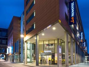 a building on the side of a street at night at Novotel Suites Hannover in Hannover