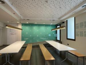 a conference room with benches and a green wall at Albergue Guiana in Ponferrada