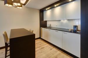 a kitchen with white cabinets and a black counter top at Hotel Monopol Luzern in Lucerne