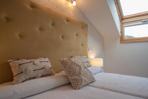 1 dormitorio con 1 cama blanca grande con almohadas en El Refugio de Cangas - Para 6/8p, en Cangas de Onís