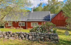 a red barn and a stone wall in front of a house at Cozy Home In Hishult With Kitchen in Knäred