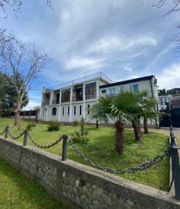 a large white house with a fence in front of it at House on Moryakov 55 in Chakvi