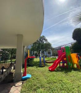 a playground with colorful play equipment in the grass at House on Moryakov 55 in Chakvi
