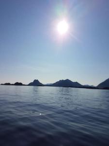 um corpo de água com o sol no céu em Hus i vakre Lofoten em Stamsund