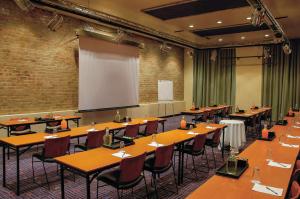a classroom with tables and chairs and a projection screen at Garden Court Victoria Junction in Cape Town