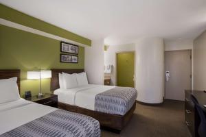 Habitación de hotel con 2 camas y paredes verdes en SureStay Plus by Best Western Mesa Superstition Springs en Mesa