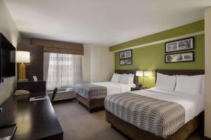 メサにあるSureStay Plus by Best Western Mesa Superstition Springsのベッド2台とテレビが備わるホテルルームです。