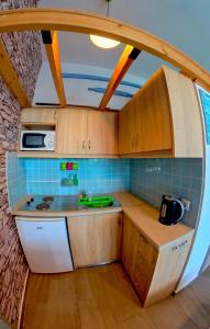 a small kitchen with a sink and a microwave at Beach Studio - Sleeps 2 & Private Ocean Terrace in Haraki +4 photos