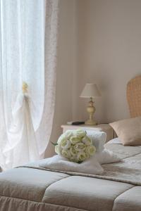 two beds with white curtains and a bouquet of roses at Giramondo LuxeFierairport in Fiumicino