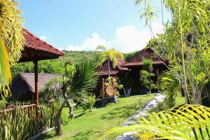 a group of houses in a garden with trees at Bamboo Bungalow Jungle View in Nusa Penida