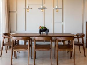 a dining room with a wooden table and chairs at Zuzu Riviera Living in Hersonissos +39 photos