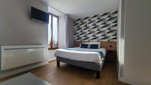 1 dormitorio con 1 cama y TV de pantalla plana en Logis Hôtel Auberge de l'Allagnonette en Saint-Poncy