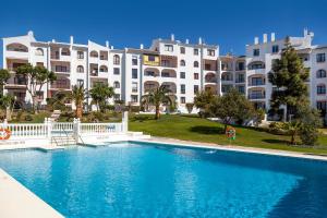 a swimming pool in front of a large building at Riviera del Mar apartment in Mijas Costa