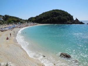 a beach with a bunch of people and the ocean at Center of Parga-John's House in Parga