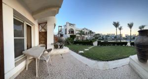een balkon van een huis met een tafel en een tuin bij Homie 1- master bedroom, pool and garden view in Sharm el Sheikh in Sharm El Sheikh