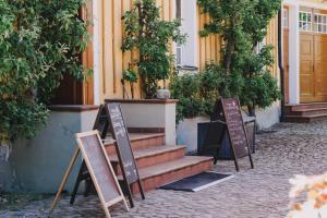 dos letreros frente a un edificio con escaleras en Gasthof Zum Hirsch en Drehna