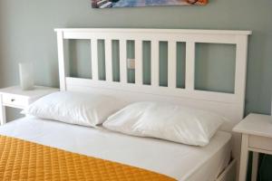 a white bed with two pillows on top of it at Center of Parga-John's House in Parga