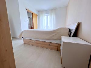 um pequeno quarto com uma cama e uma janela em Stel Mar Apartment em Rab