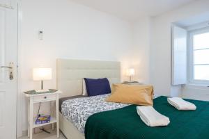ein Schlafzimmer mit einem Bett mit zwei Lampen in der Unterkunft A Treat in Belém in Lissabon