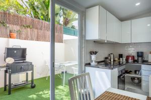 une cuisine avec des armoires blanches et une cuisinière dans l'établissement A Treat in Belém, à Lisbonne