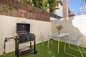 een patio met een grill en een tafel met stoelen bij A Treat in Belém in Lissabon