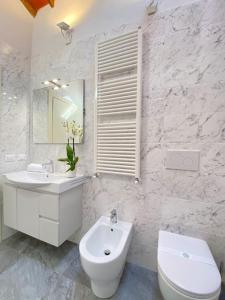 ein weißes Bad mit einem Waschbecken und einem WC in der Unterkunft Relax&Business [Wi-fi, TV HD, Parcheggio gratuito] in Capannori